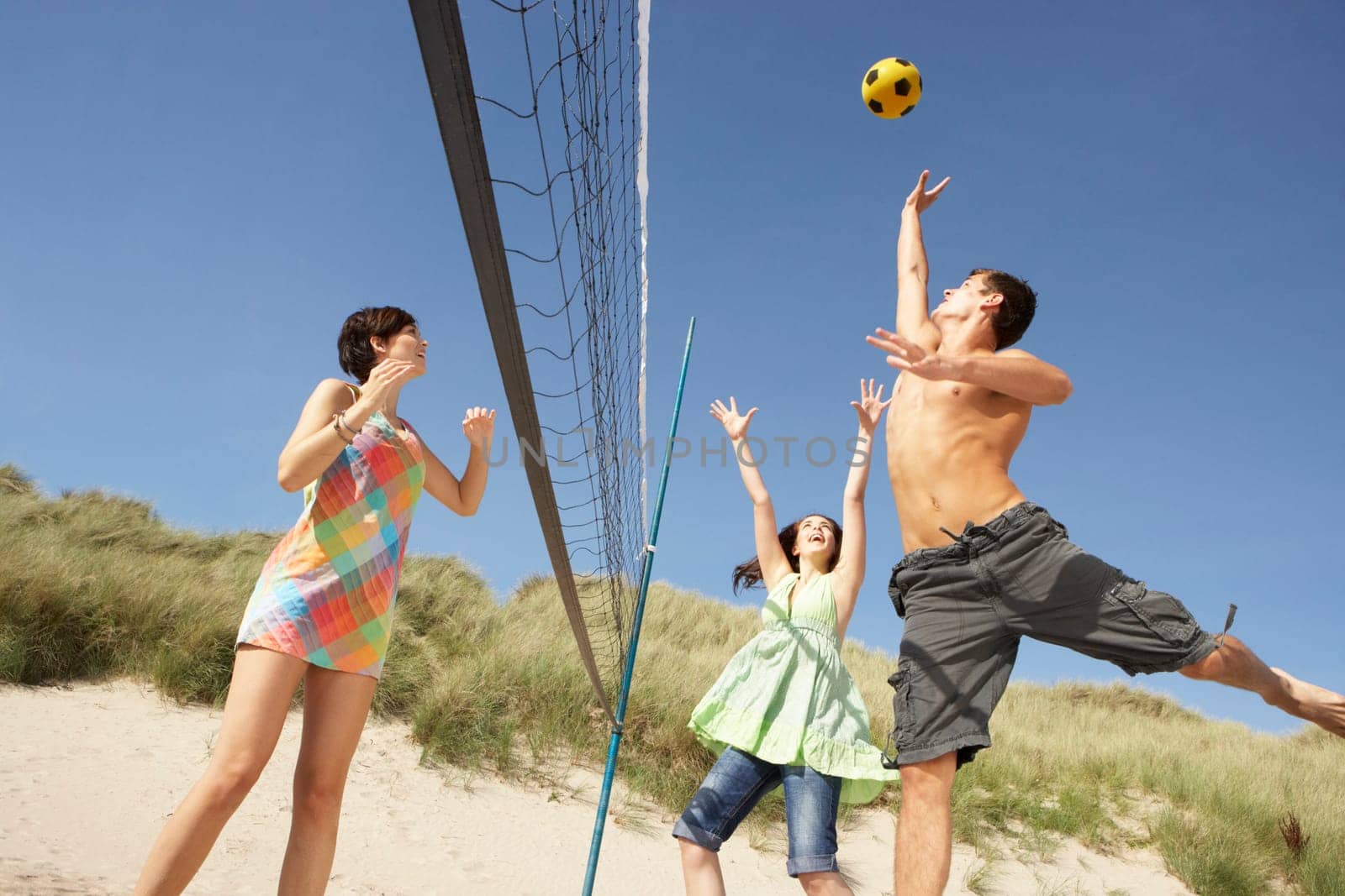 Group Of Teenage Friends Playing Volleyball On Beach