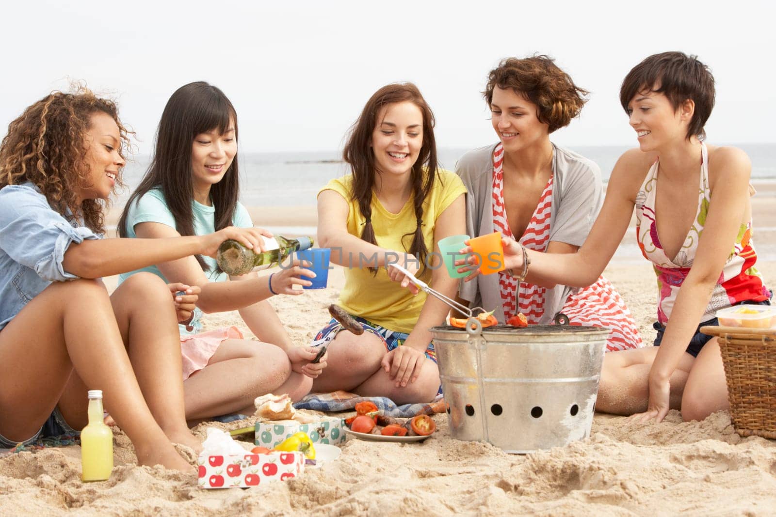 Group Of Girls Enjoying Barbeque On Beach Together