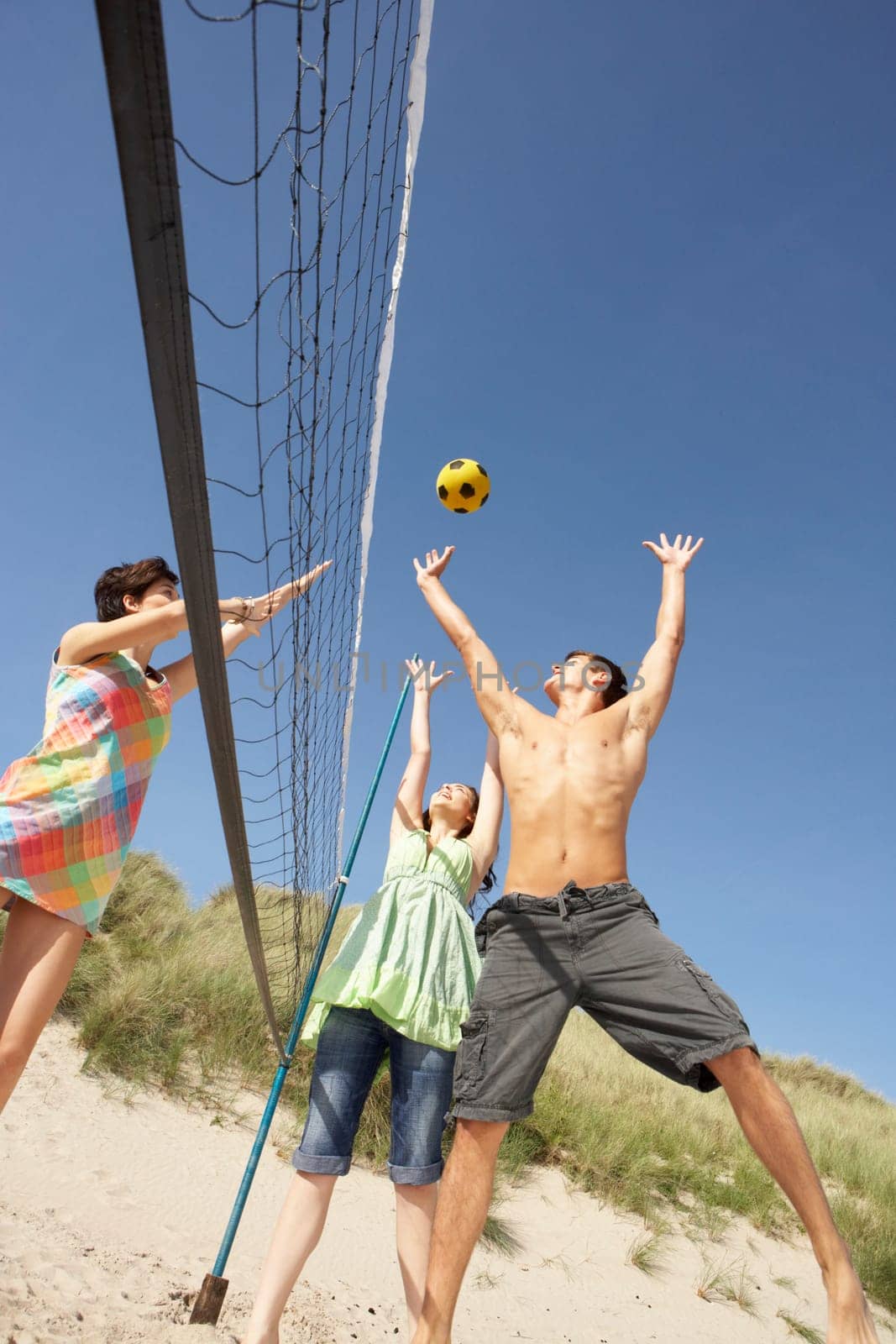 Group Of Teenage Friends Playing Volleyball On Beach