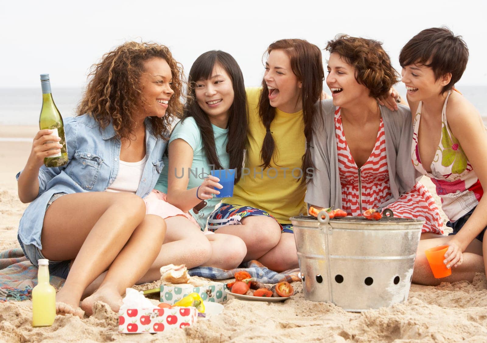 Group Of Girls Enjoying Barbeque On Beach Together