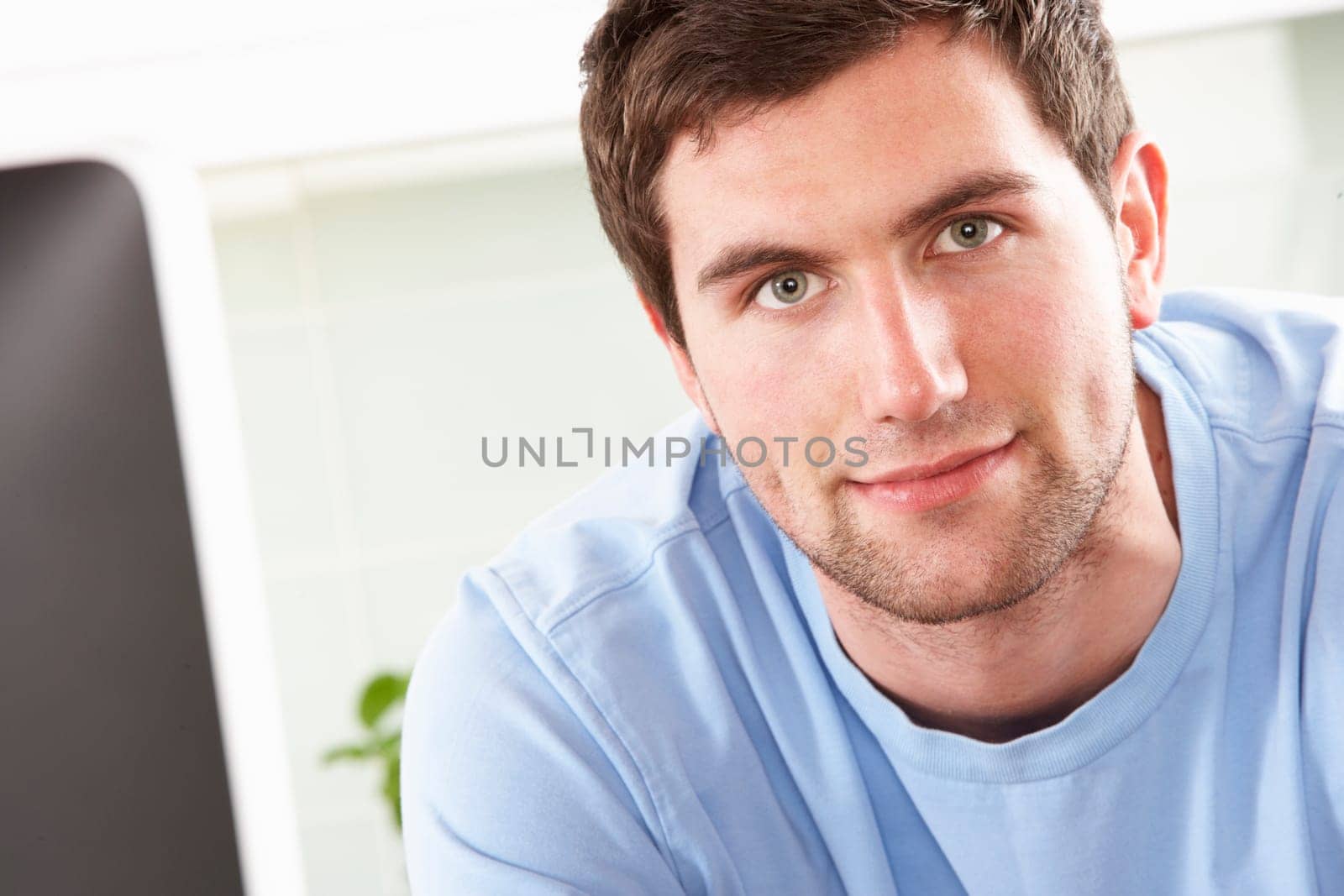 Young Man Using Computer In Modern Kitchen