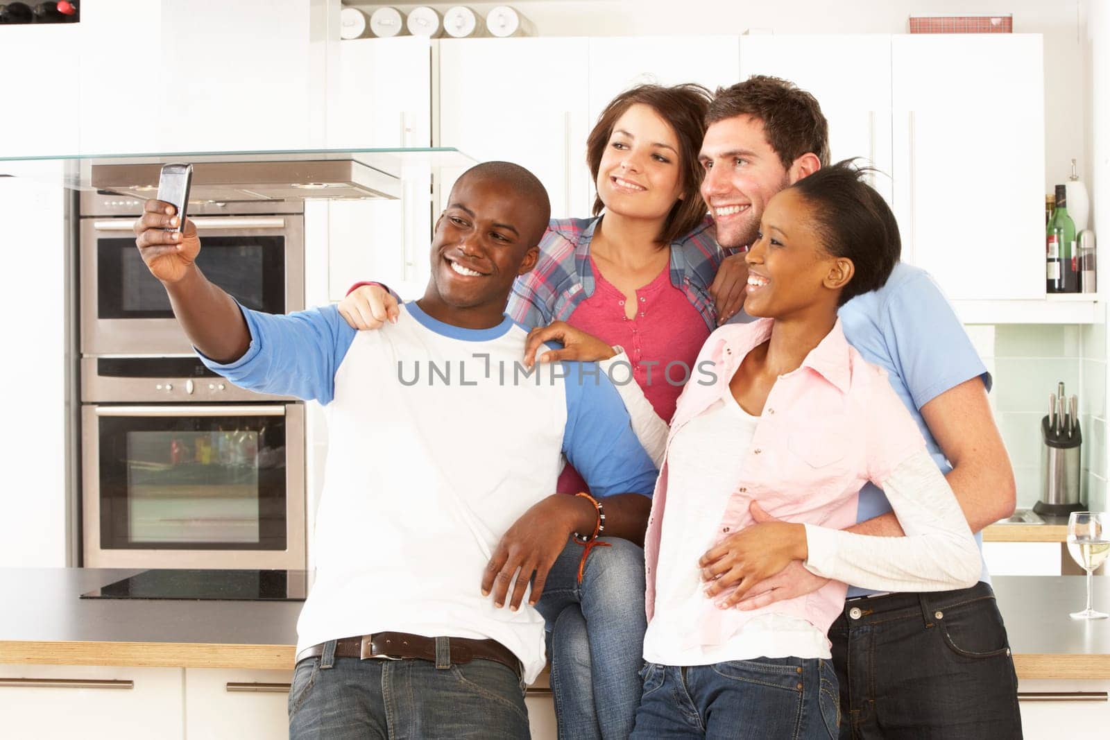 Group Of Young Friends Taking Photo In Modern Kitchen
