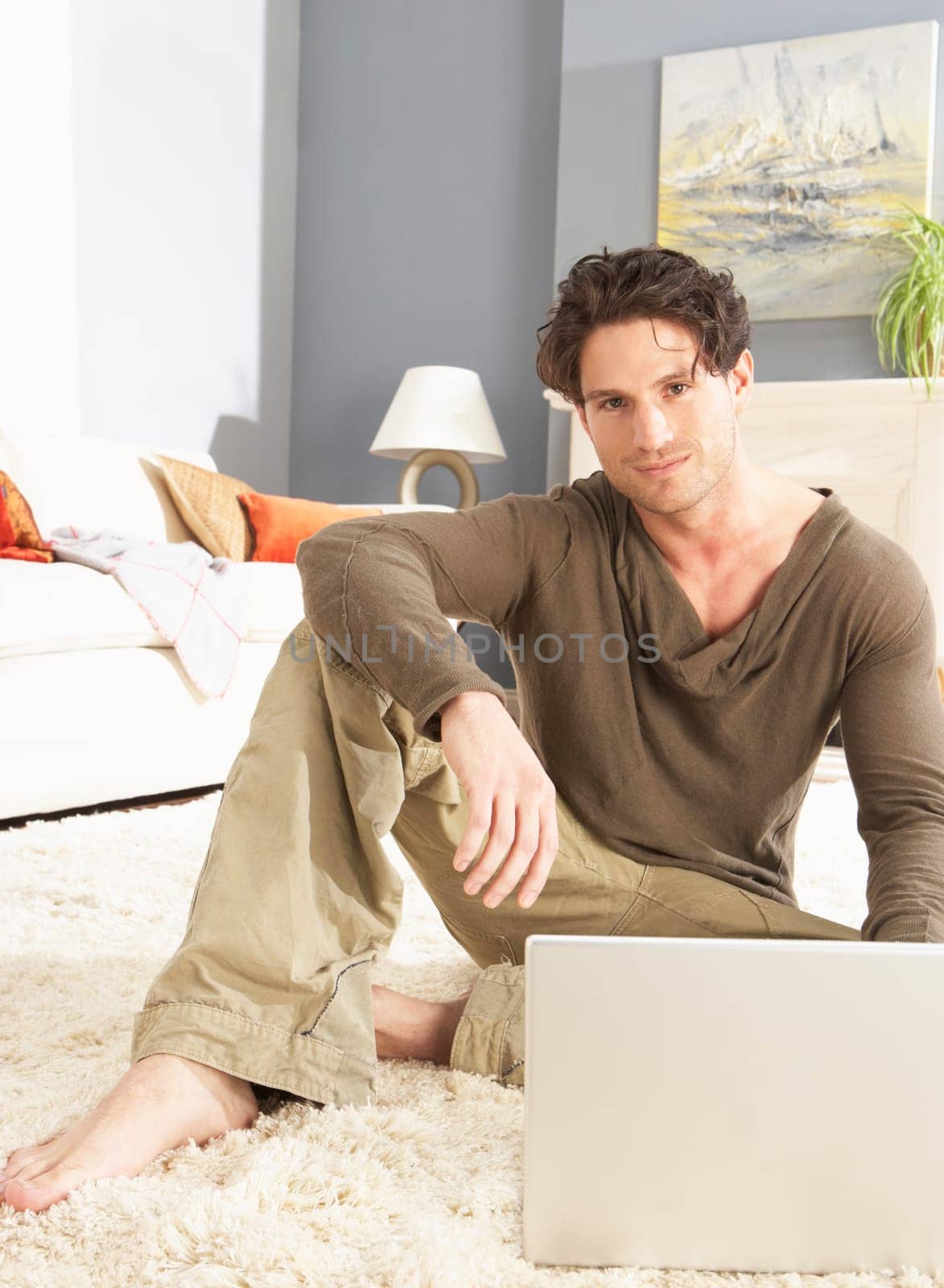 Man Using Laptop Relaxing Sitting On Rug At Home