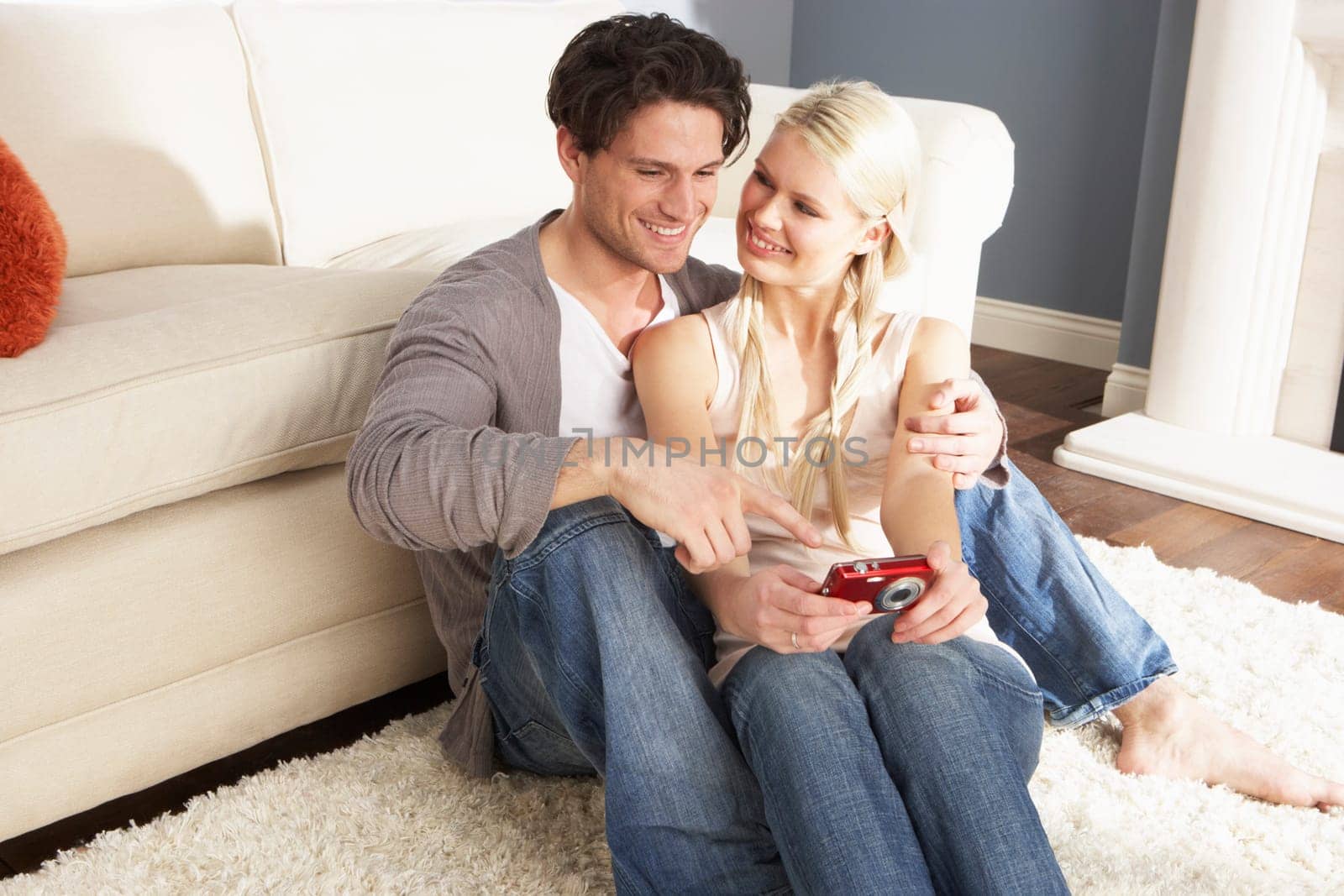 Couple Taking Photograph On Digital Camera At Home