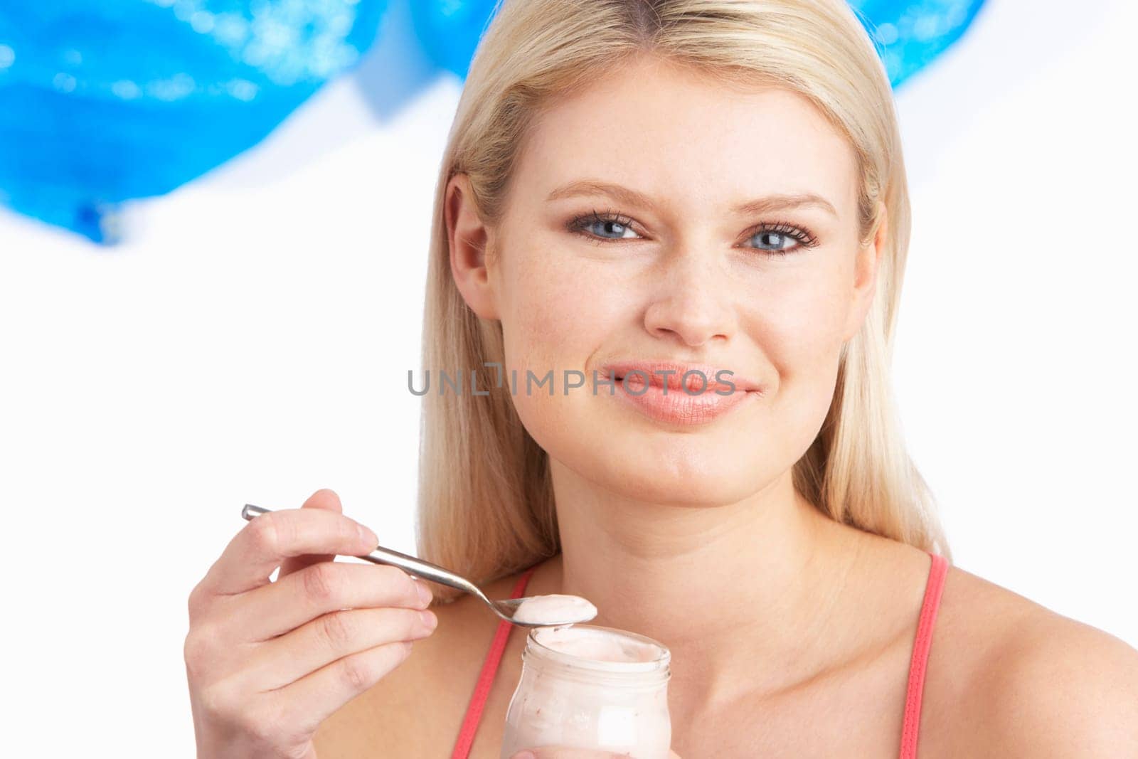 Young Woman Eating Yoghurt In Studio