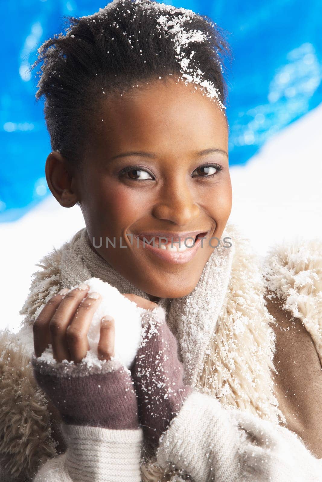 Young Woman Wearing Warm Winter Clothes Holding Snowball In Studio