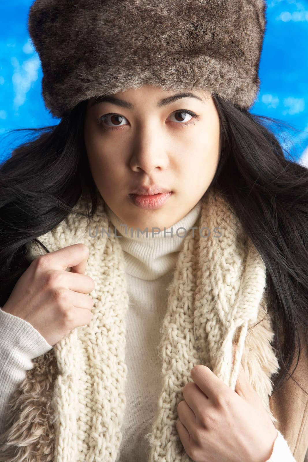 Young Woman Wearing Warm Winter Clothes And Fur Hat In Studio