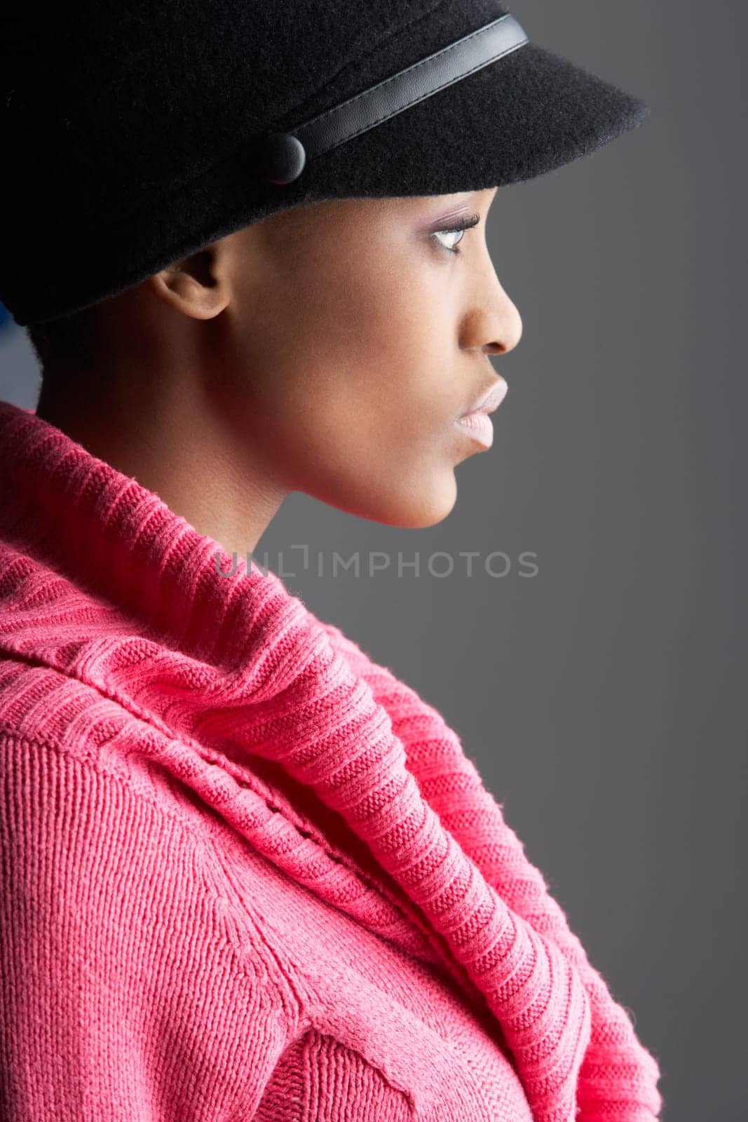Fashionable Young Woman Wearing Cap And Knitwear In Studio