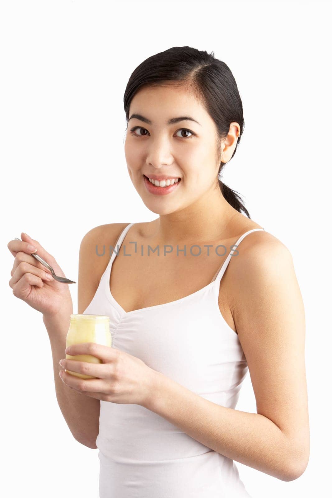 Young Woman Eating Yoghurt In Studio