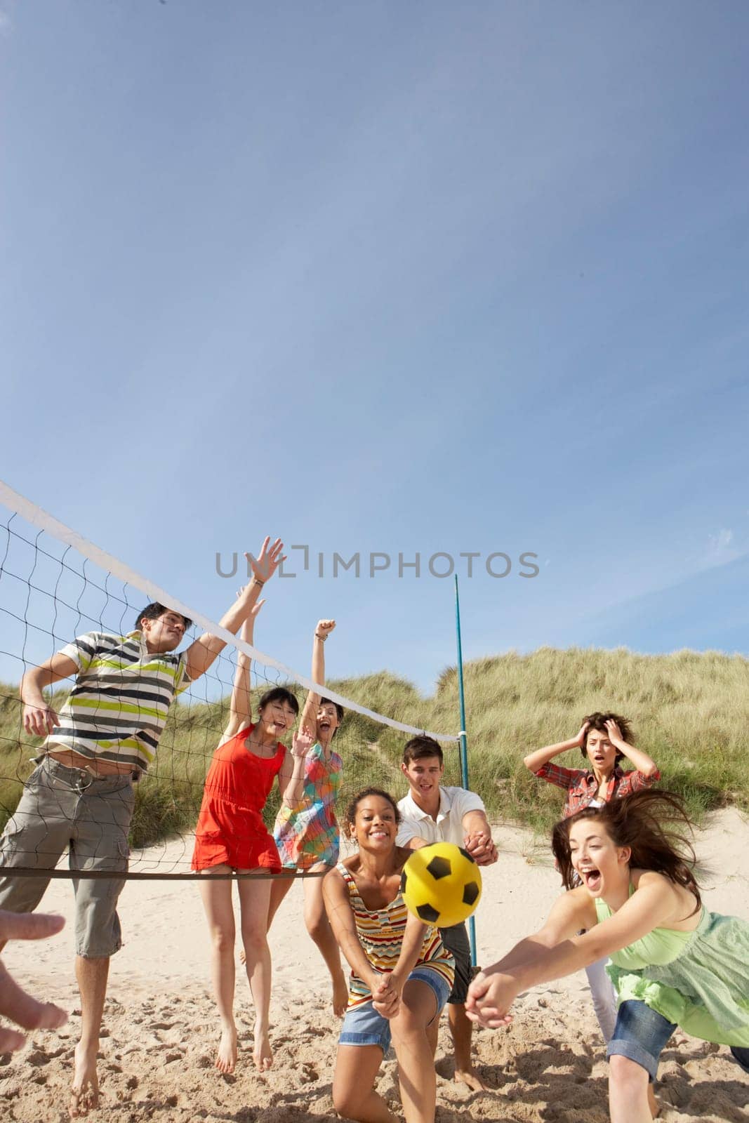 Group Of Teenage Friends Playing Volleyball On Beach