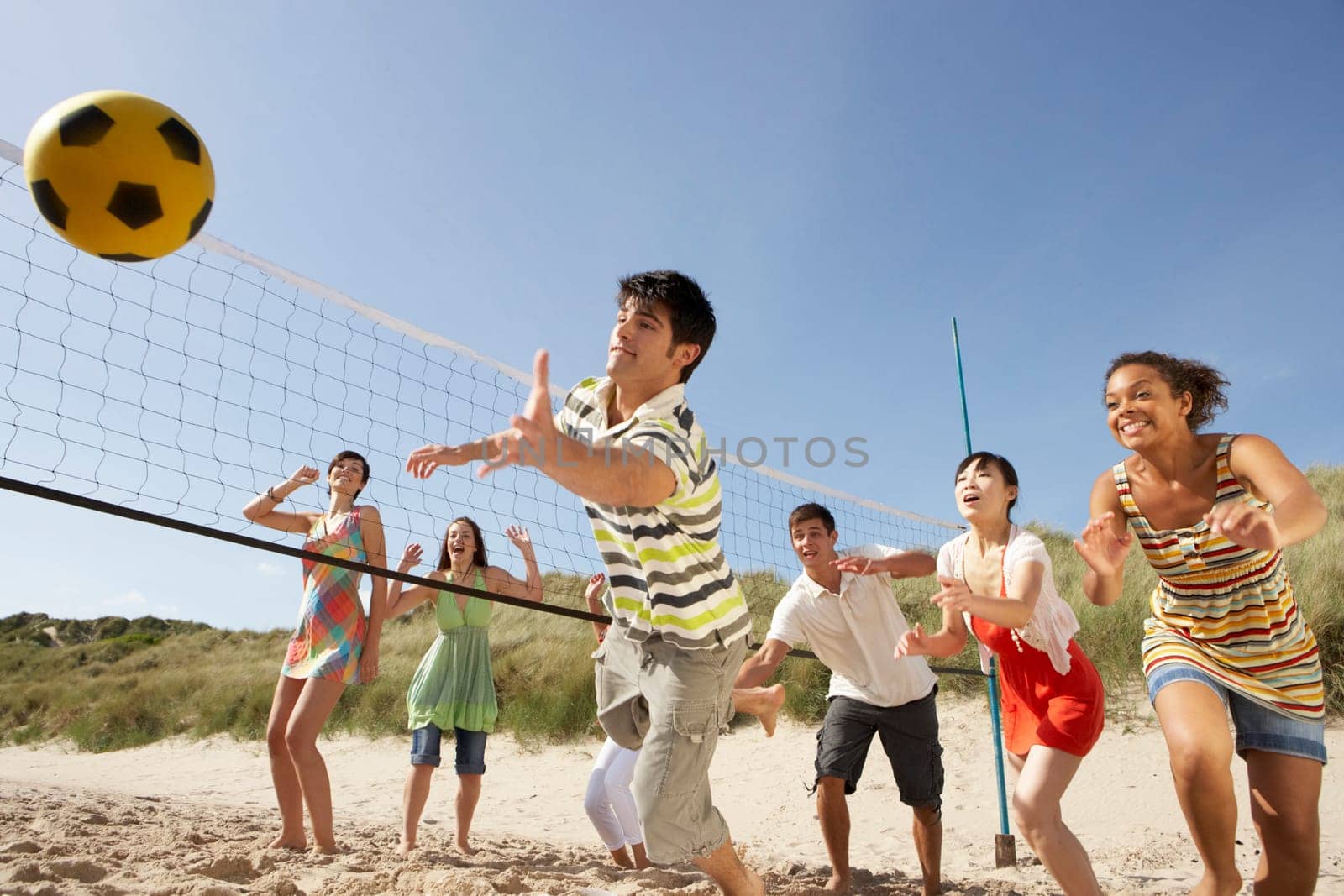 Group Of Teenage Friends Playing Volleyball On Beach