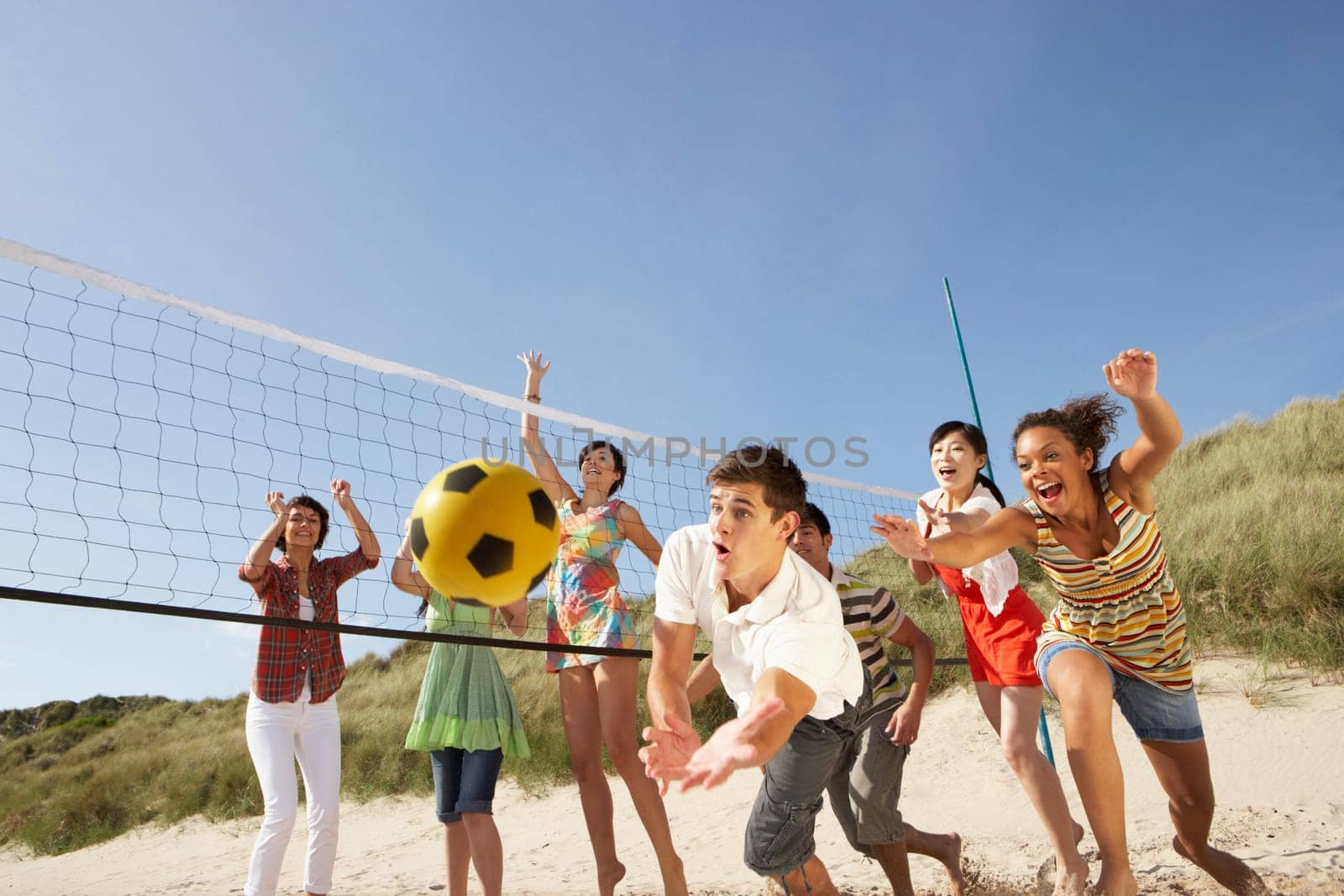 Group Of Teenage Friends Playing Volleyball On Beach