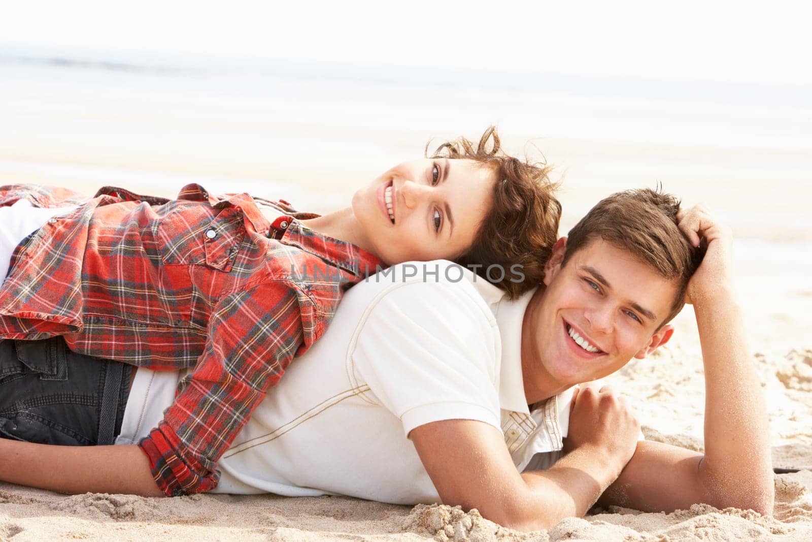 Romantic Young Couple Relaxing On Beach