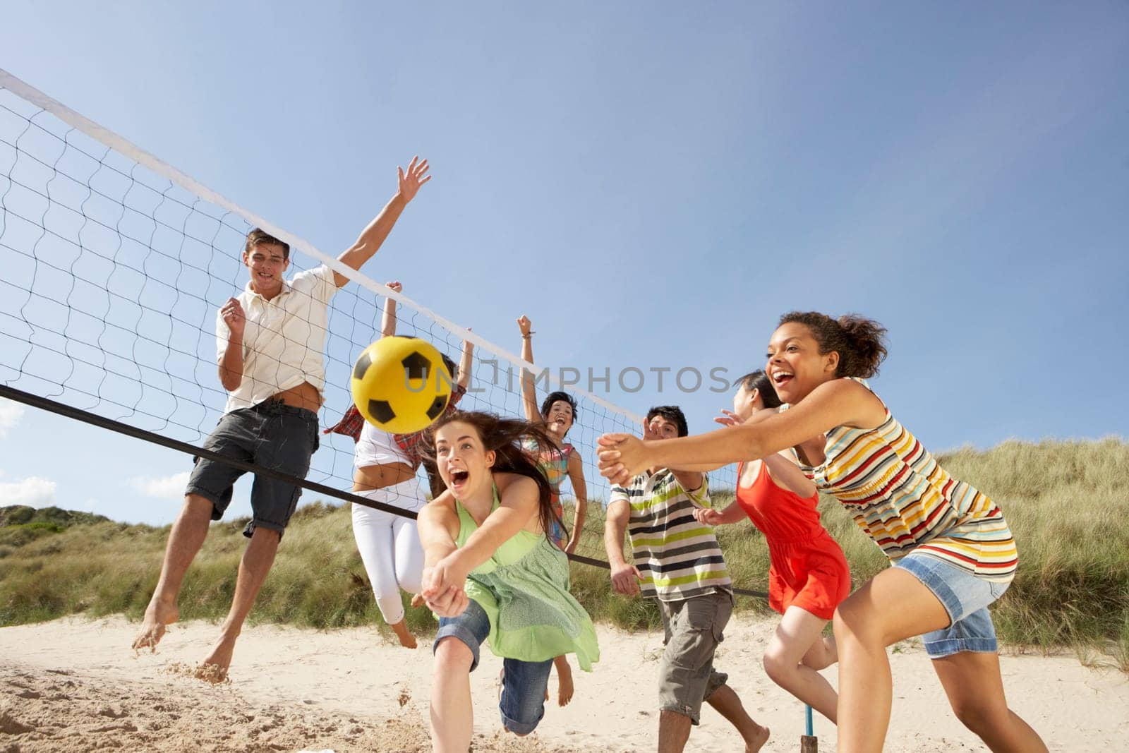 Group Of Teenage Friends Playing Volleyball On Beach