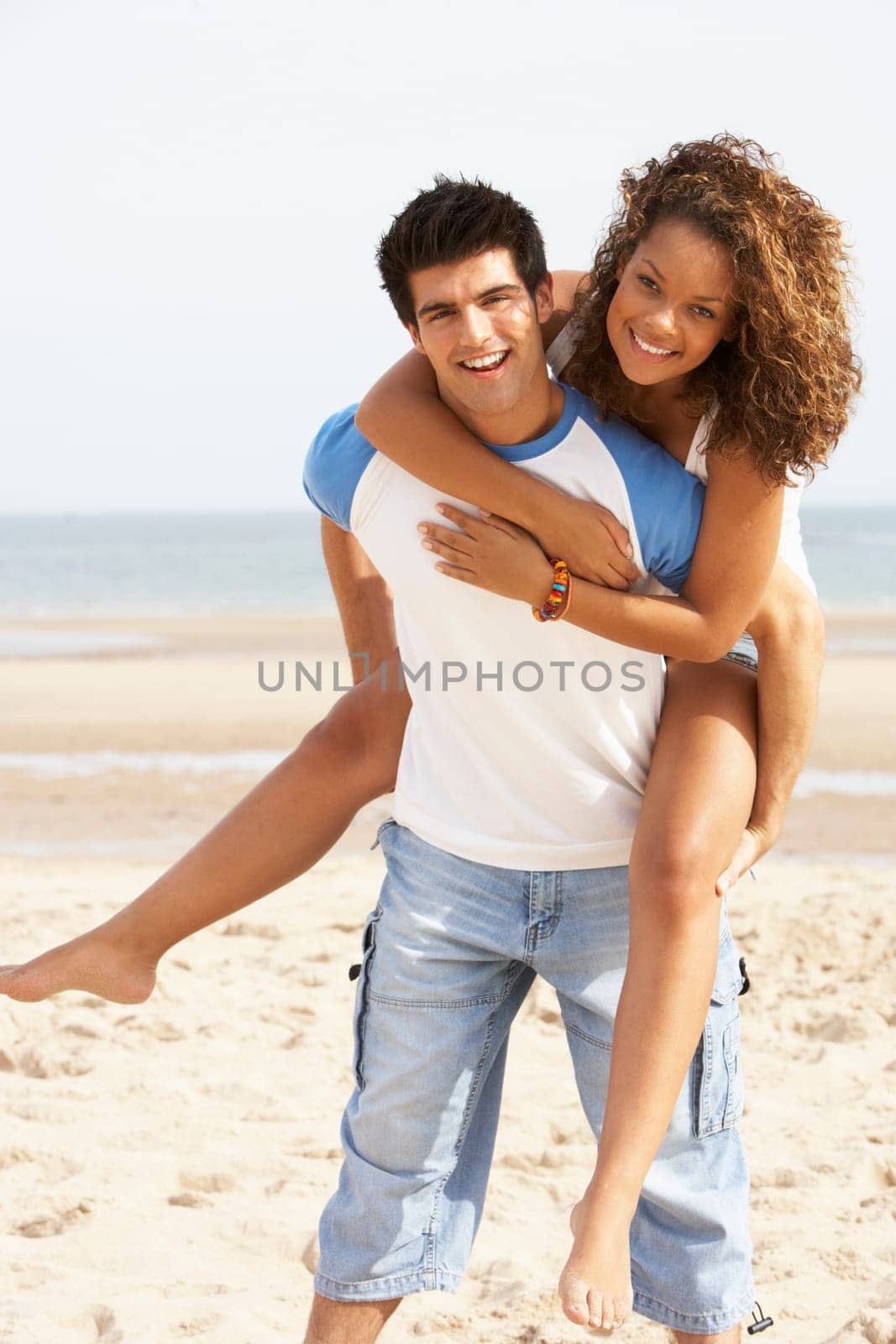 Romantic Young Couple Having Piggyback Fun On Beach