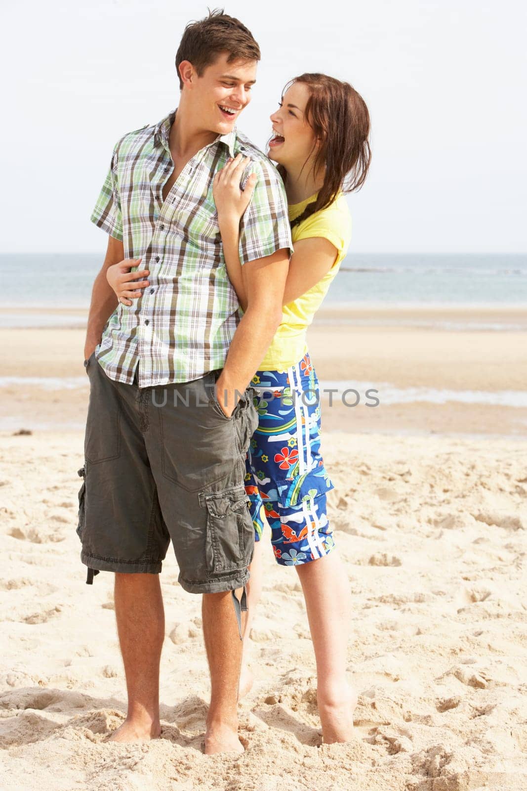 Romantic Teenage Couple Embracing On Beach