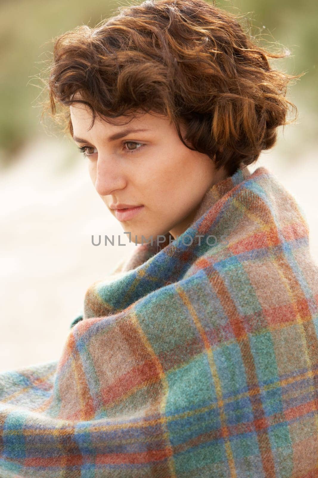 Young Woman Standing In Sand Dunes Wrapped In Blanket
