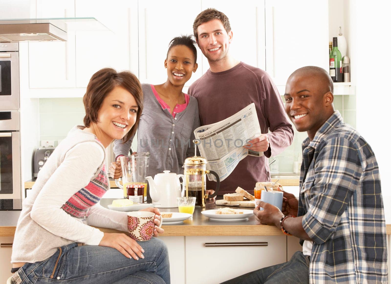 Group Of Young Friends Preparing Breakfast In Modern Kitchen