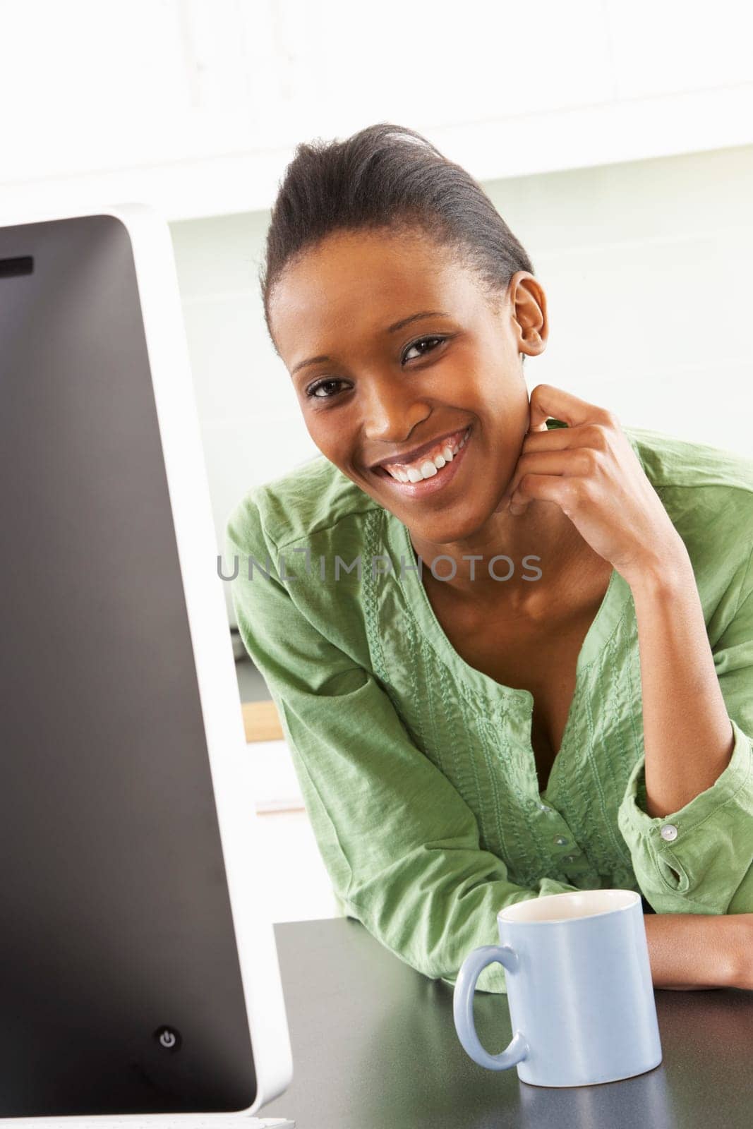 Young Woman Using Computer In Modern Kitchen