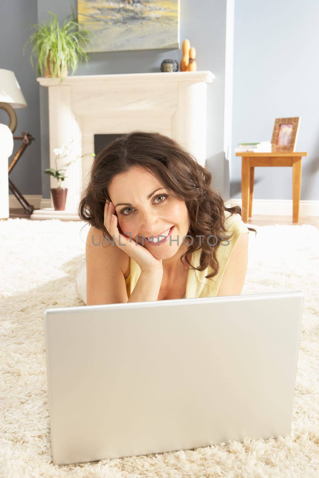 Woman Using Laptop Relaxing Laying On Rug At Home
