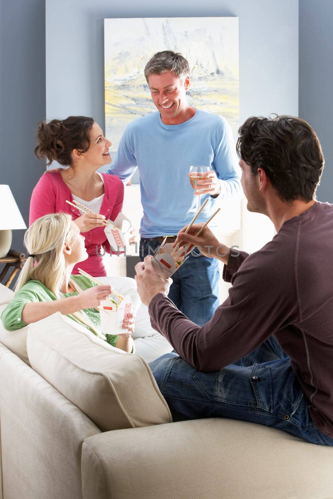 Group Of Friends Enjoying Chinese Takeaway Meal At Home