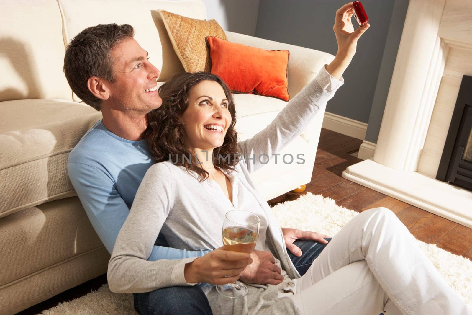 Couple Taking Photograph On Digital Camera At Home
