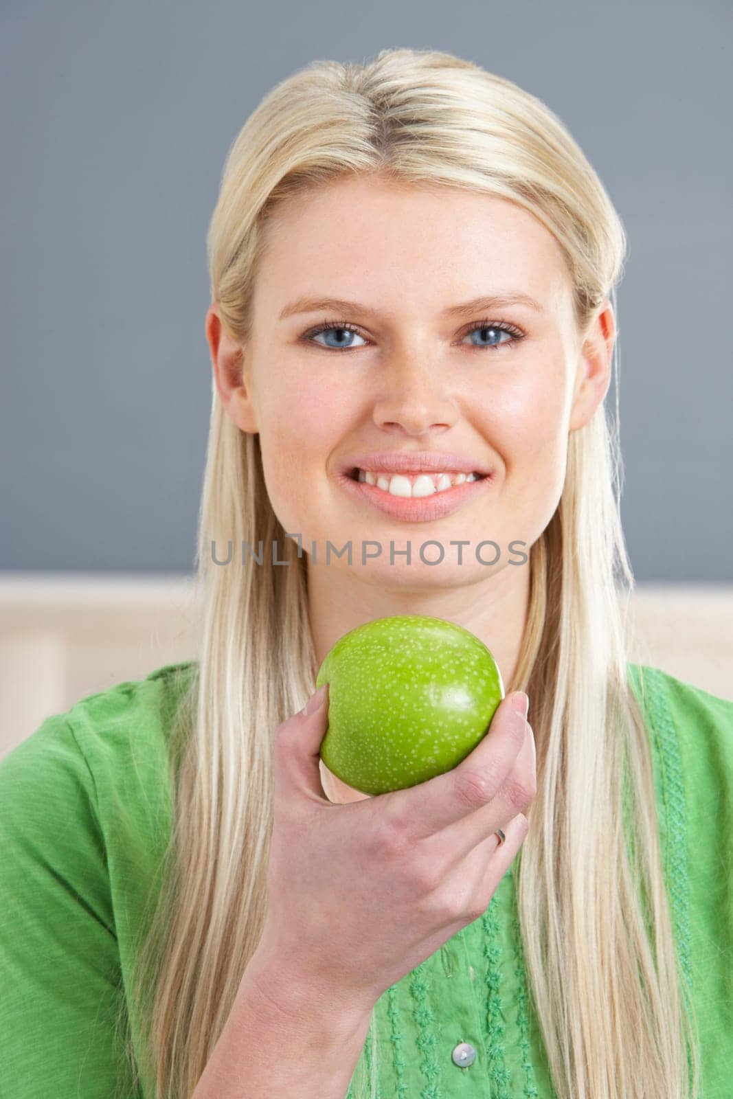 Woman Relaxing On Sofa Eating Apple At Home