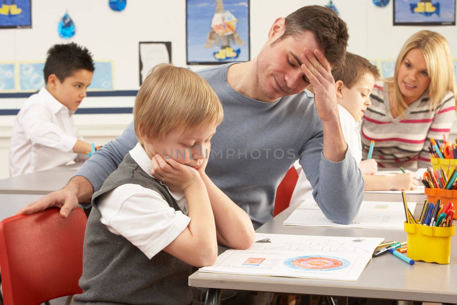 Group Of Primary Schoolchildren And Teacher Having lesson In Classroom