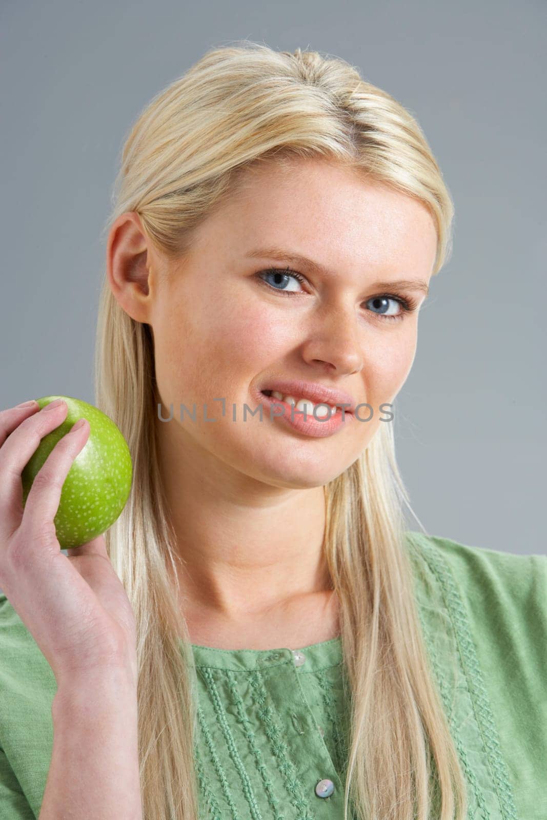 Woman Relaxing On Sofa Eating Apple At Home