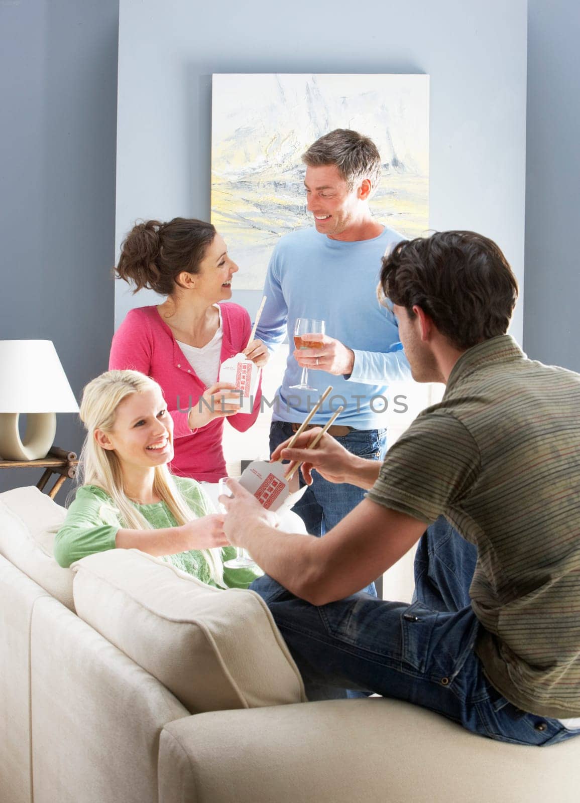 Group Of Friends Enjoying Chinese Takeaway Meal At Home