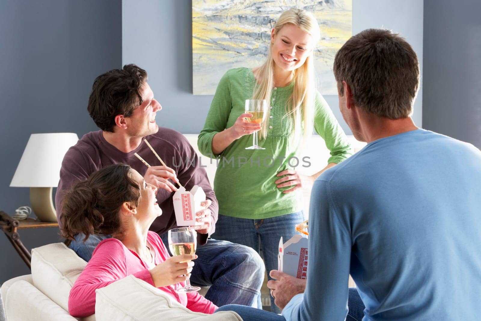 Group Of Friends Enjoying Chinese Takeaway Meal At Home
