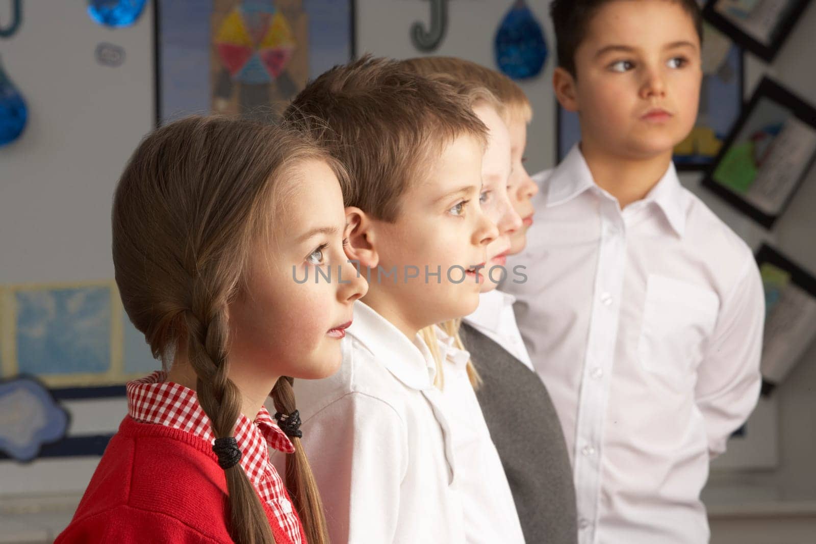 Portrait Of Group Of Primary Schoolchildren Standing In Classroom