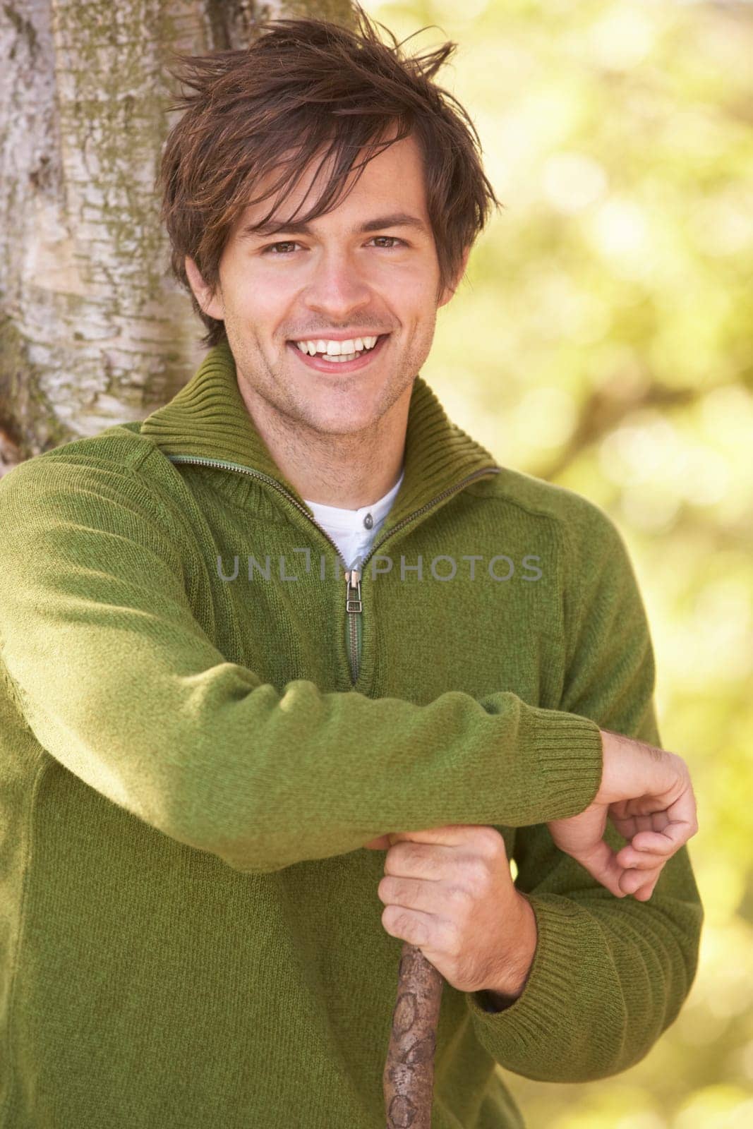 Young Man Outdoors Walking In Autumn Woodland Holding Walking Stick