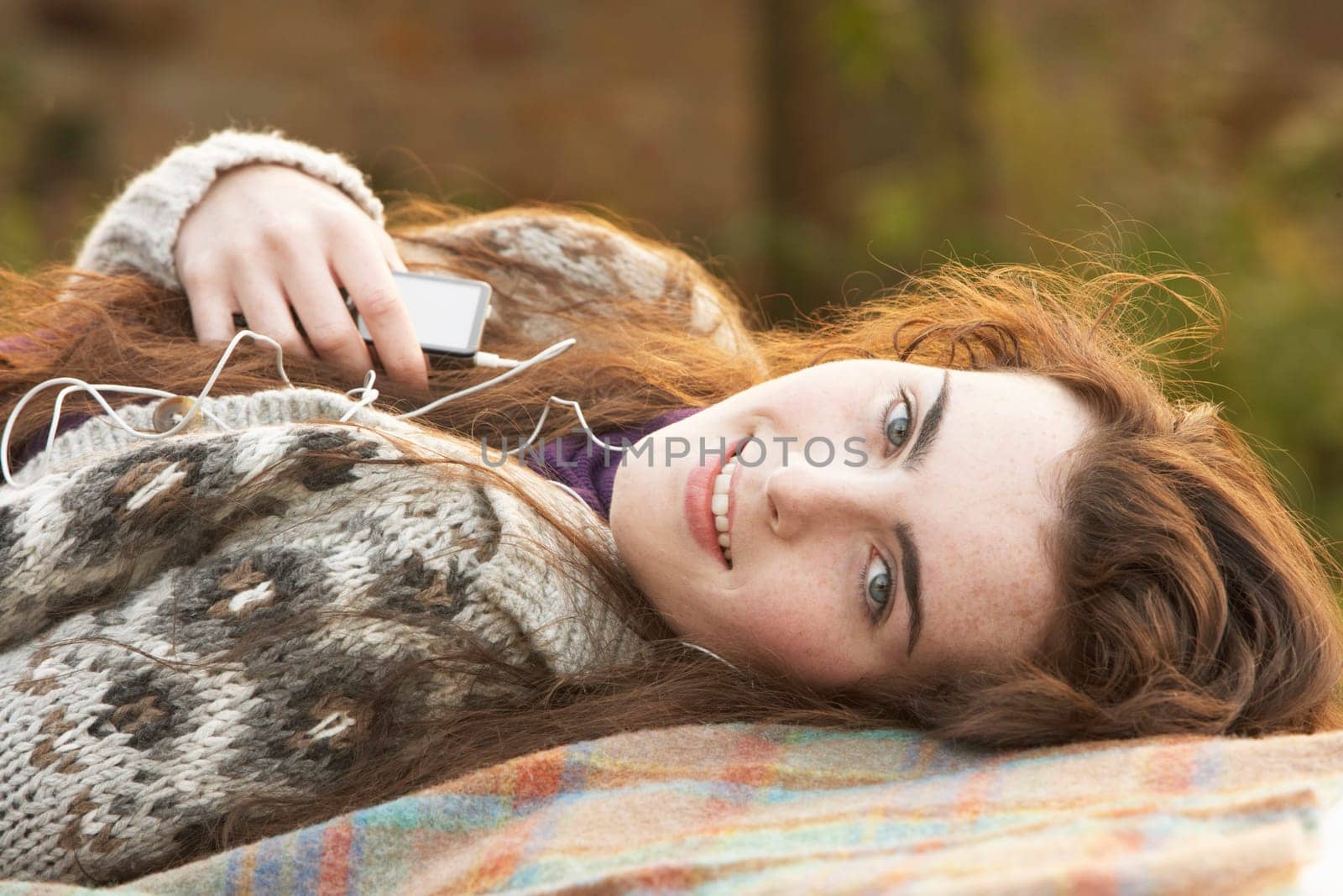 Portrait Of Beautiful Teenage Girl Outdoors Listening To MP3 Player In Autumn Landscape
