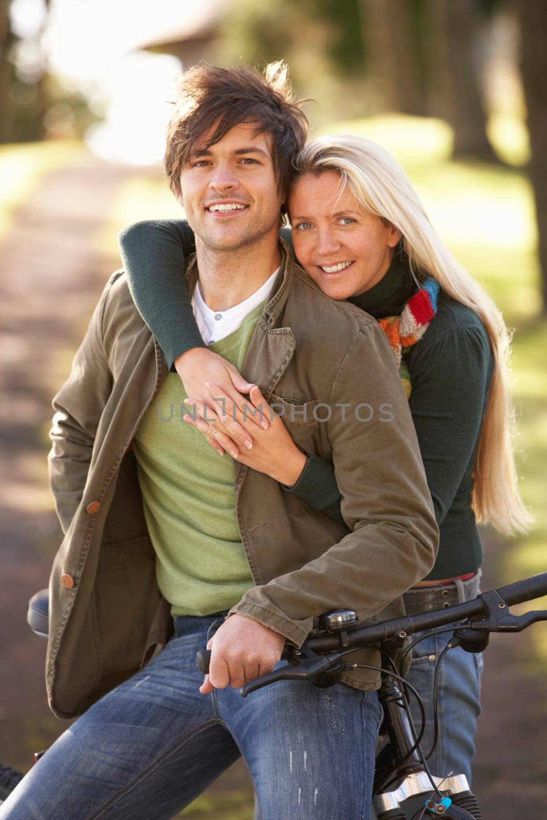 Portrait Of Young Couple With Cycle In Autumn Park