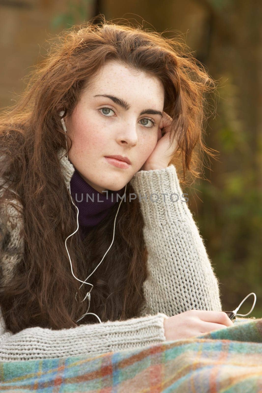 Portrait Of Beautiful Teenage Girl Outdoors Listening To MP3 Player In Autumn Landscape