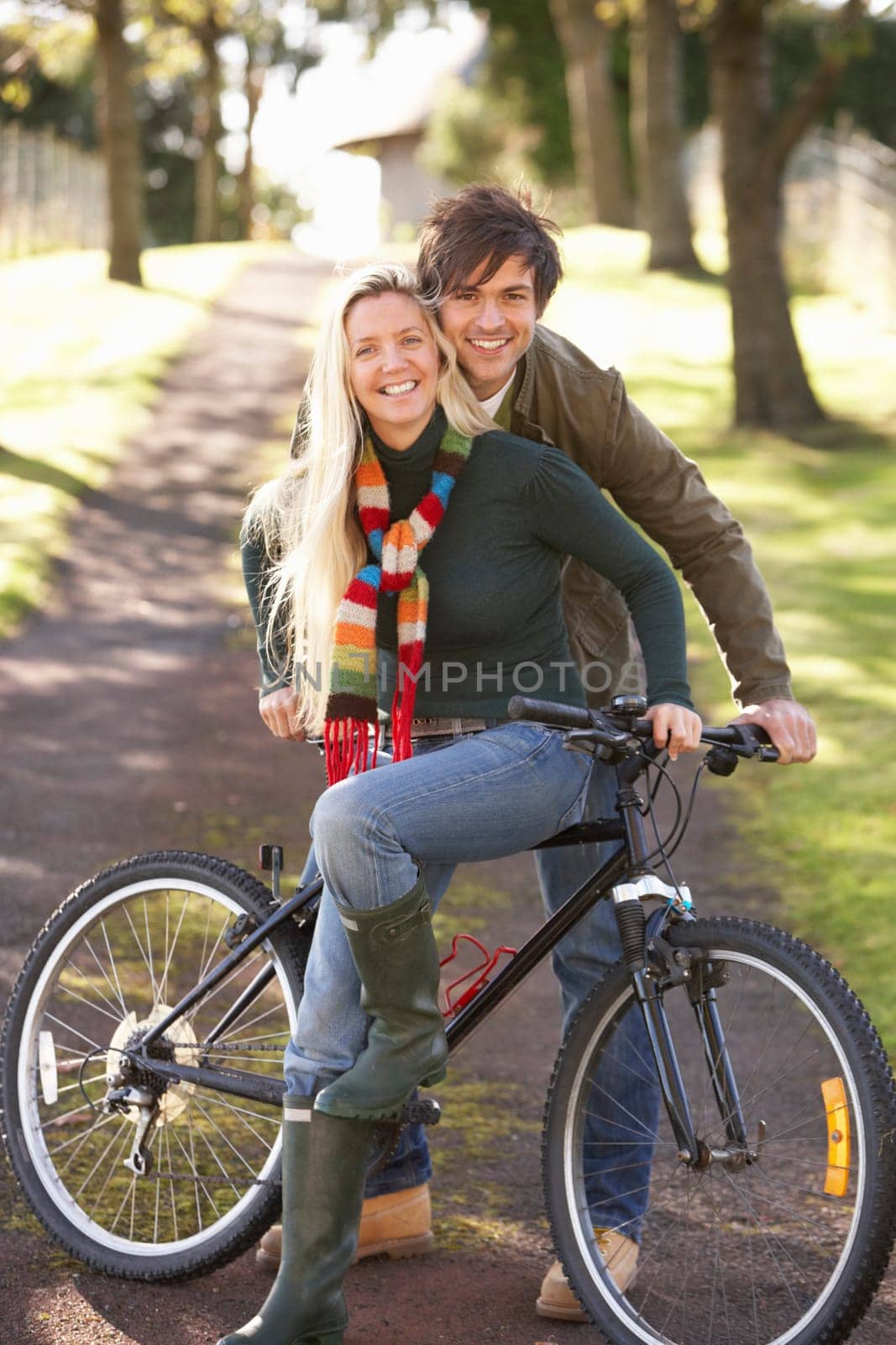 Portrait Of Young Couple With Cycle In Autumn Park