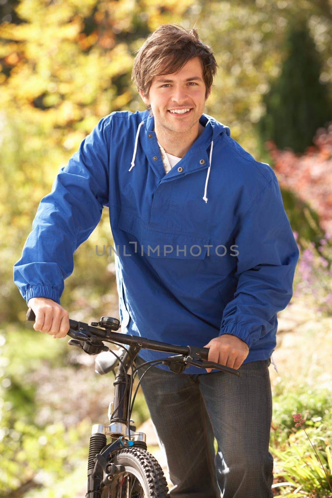Portrait Of Young Man With Cycle In Autumn Park