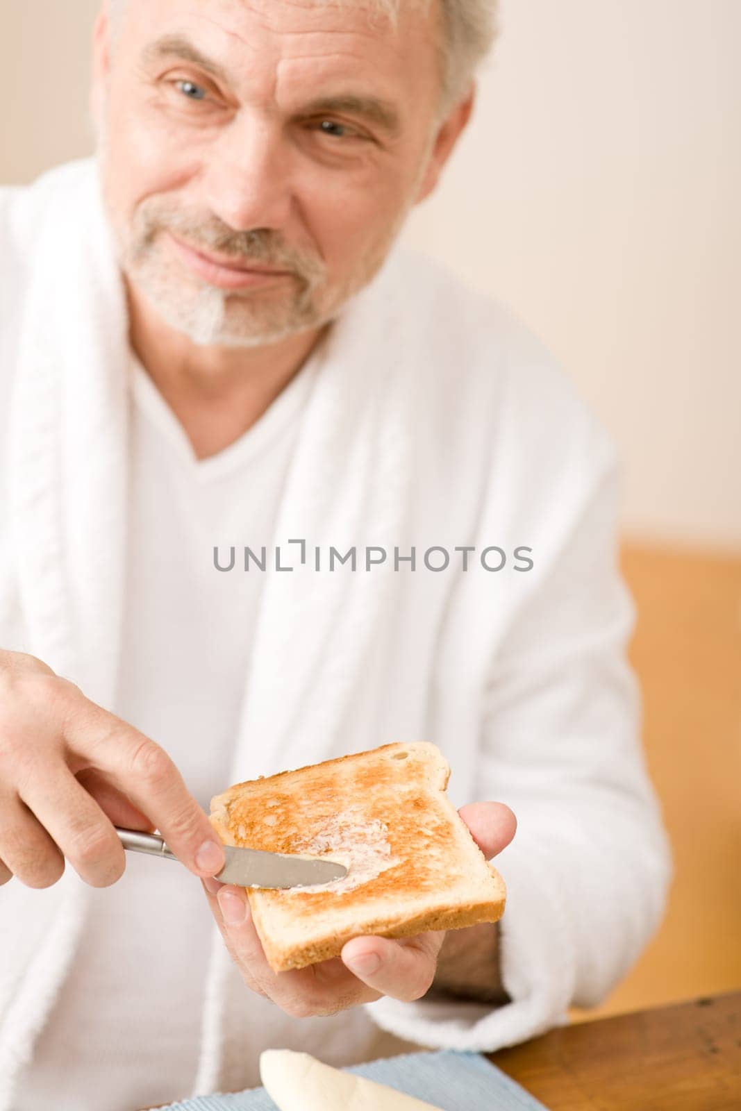 Senior mature man having breakfast toast