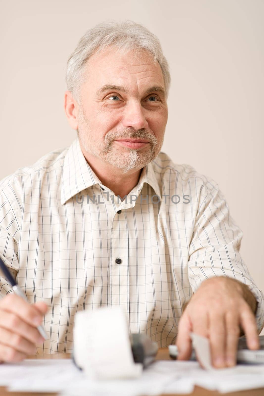 Senior mature man - home office paper tape calculator