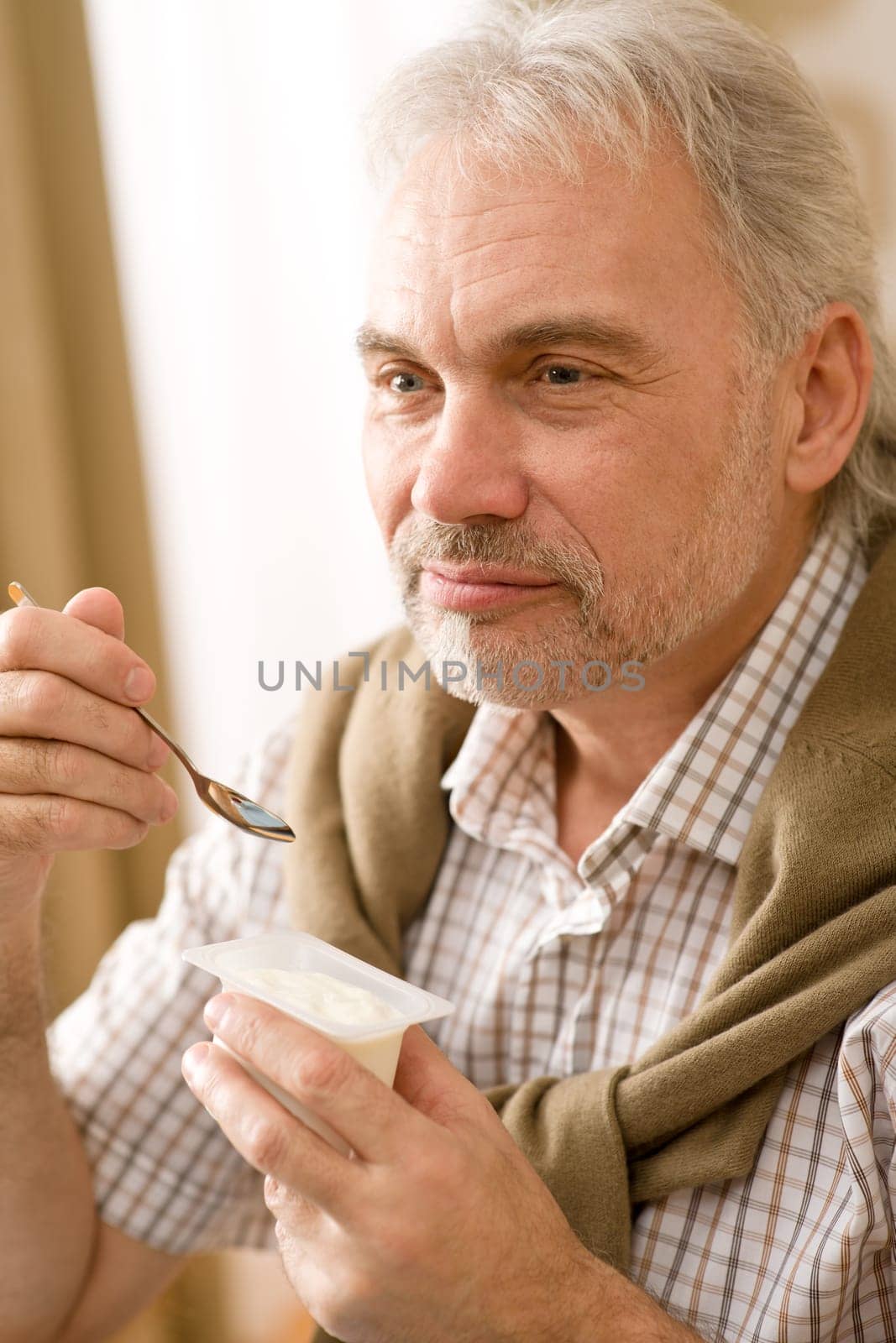 Senior mature man eat yogurt snack