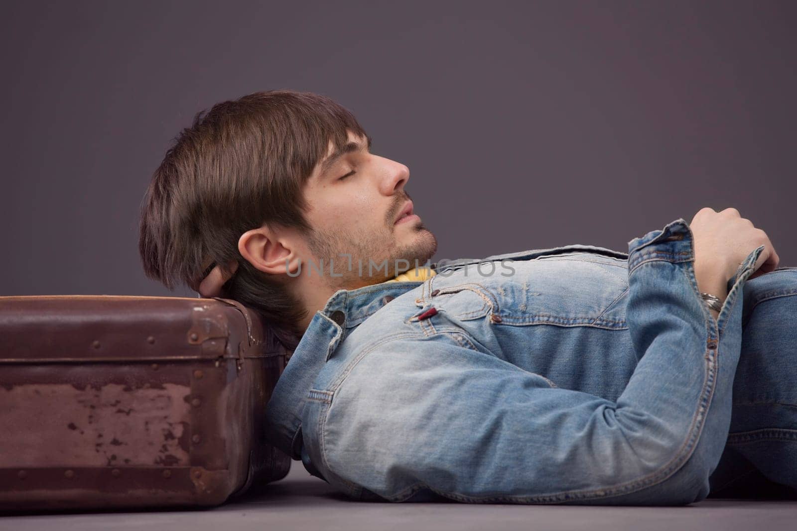 man sleeping on suitcase