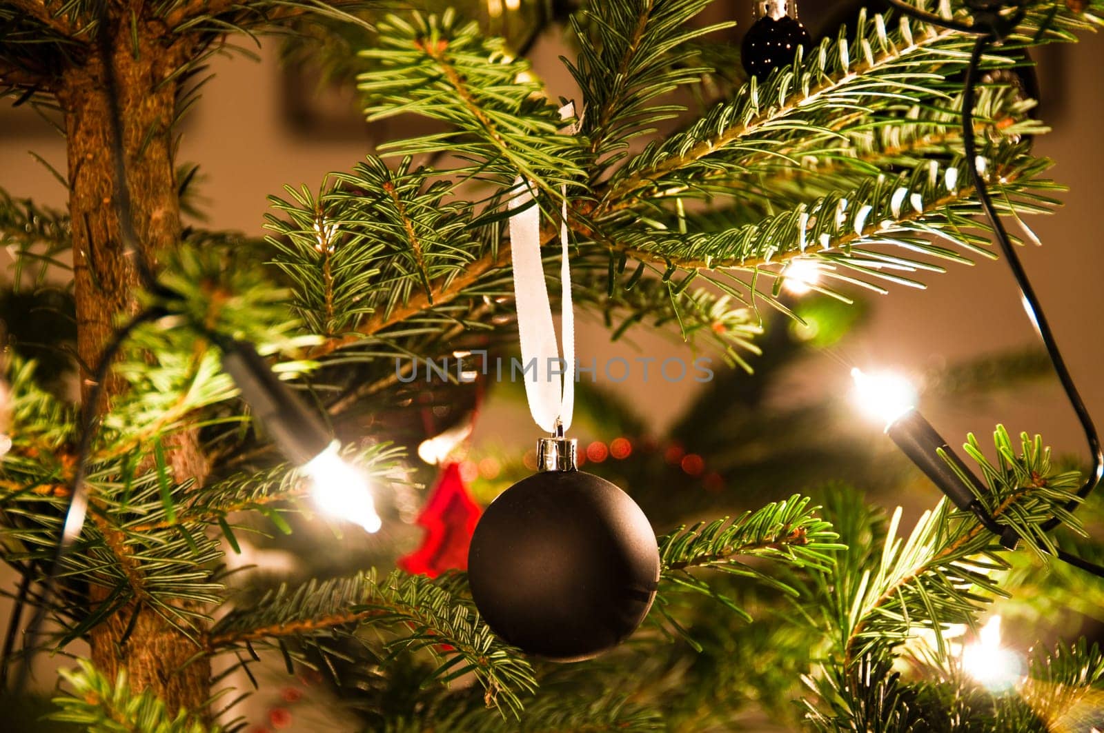 Christmas ball hanging from Christmas tee with lights