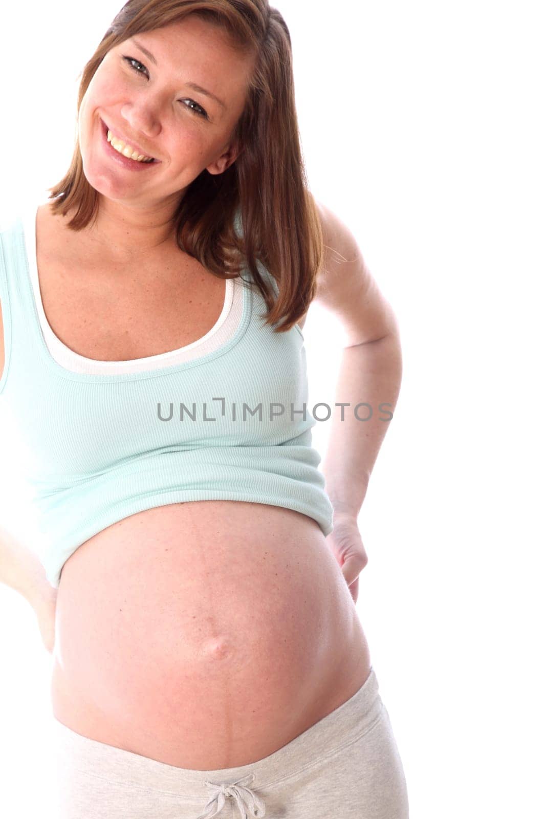 Pregnant woman in the ninth month smiling at the camera