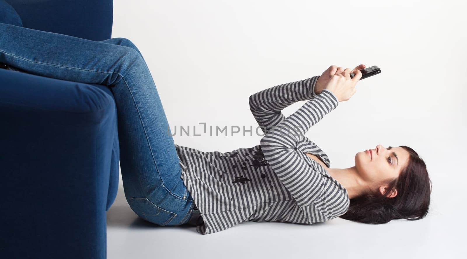 Pretty young brunette woman sending SMS from her cellphone
