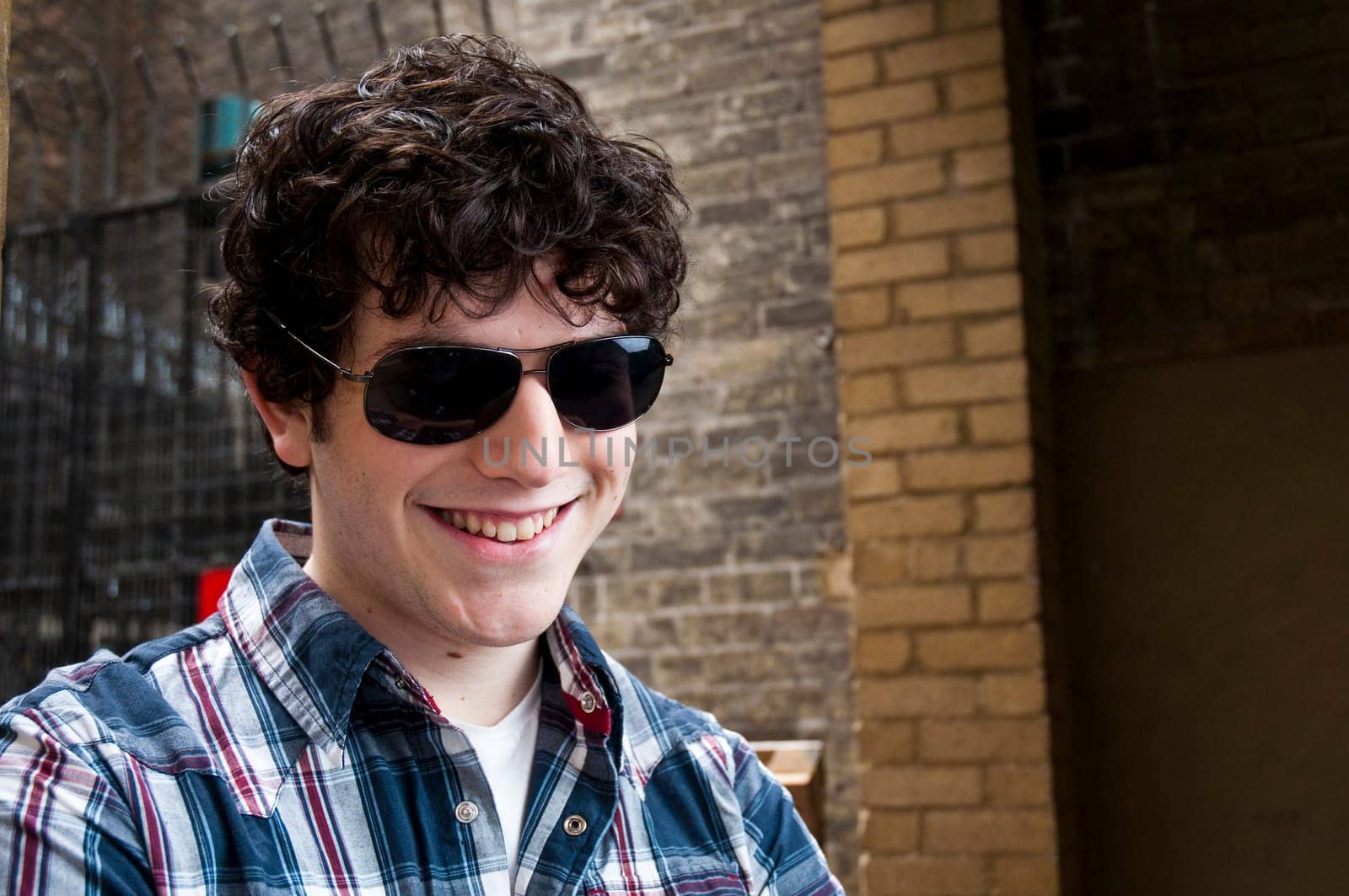 Portrait of young man wearing sun glasses and smiling