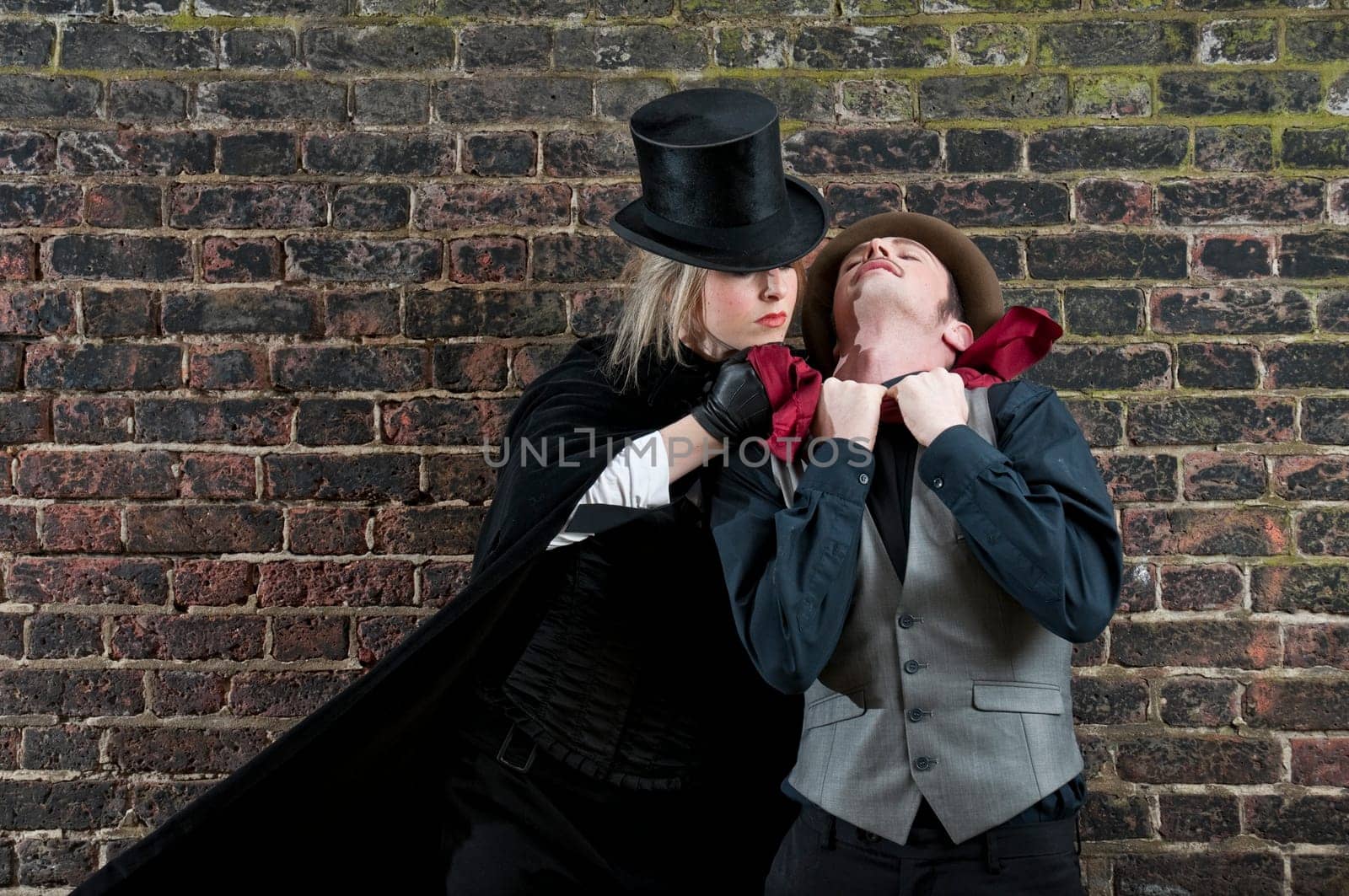 Fashion shot of woman  dressed as Jack the Ripper strangling man