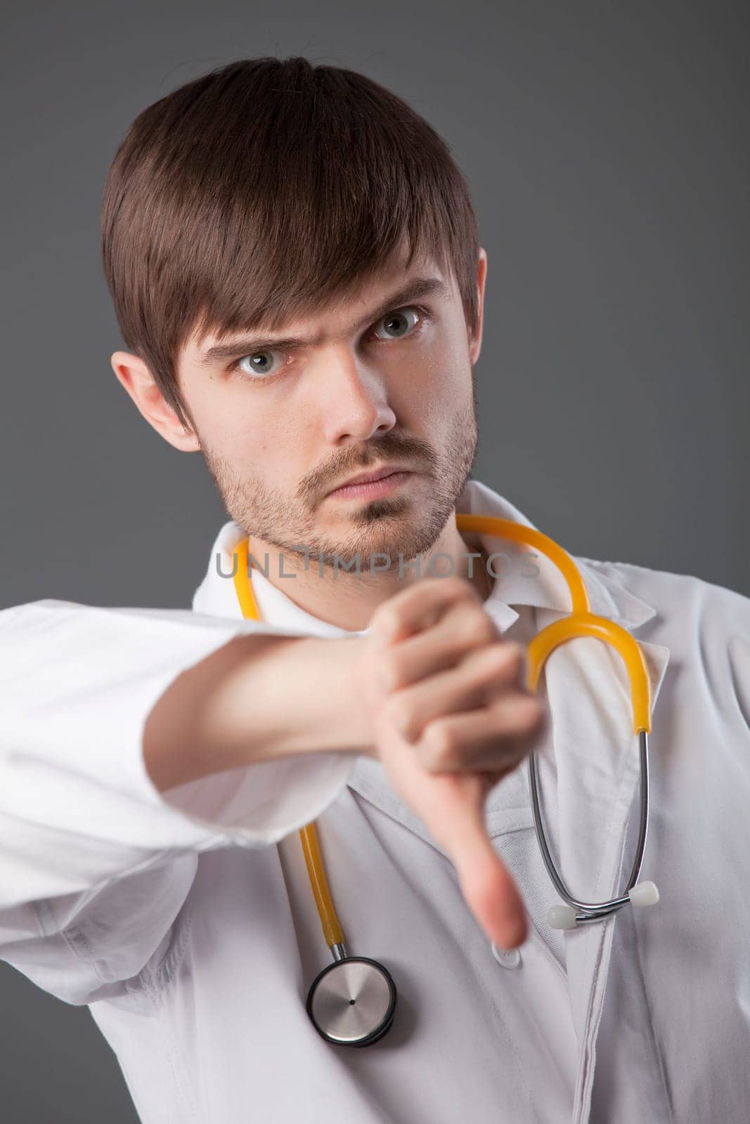 unhappy male doctor with thumbs down sign