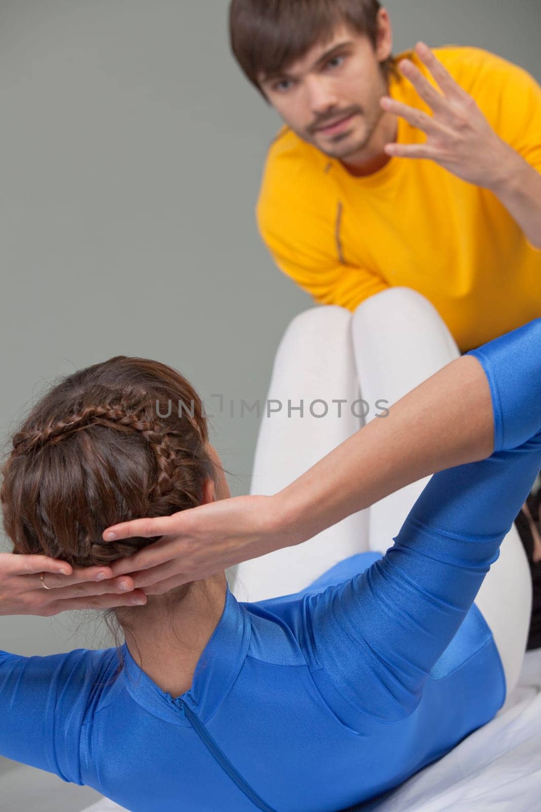young woman doing sit-ups with personal trainer