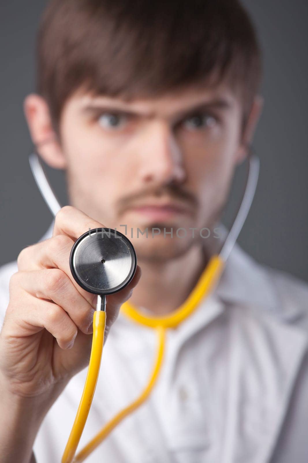 Doctor using stethoscope - focus on hand in foreground